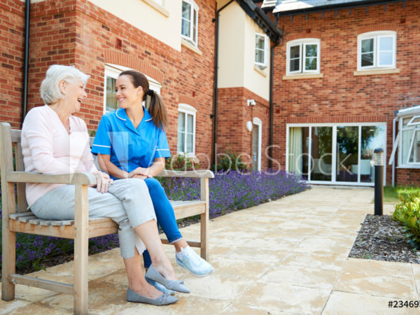 senior and employee sitting on bench outdoors