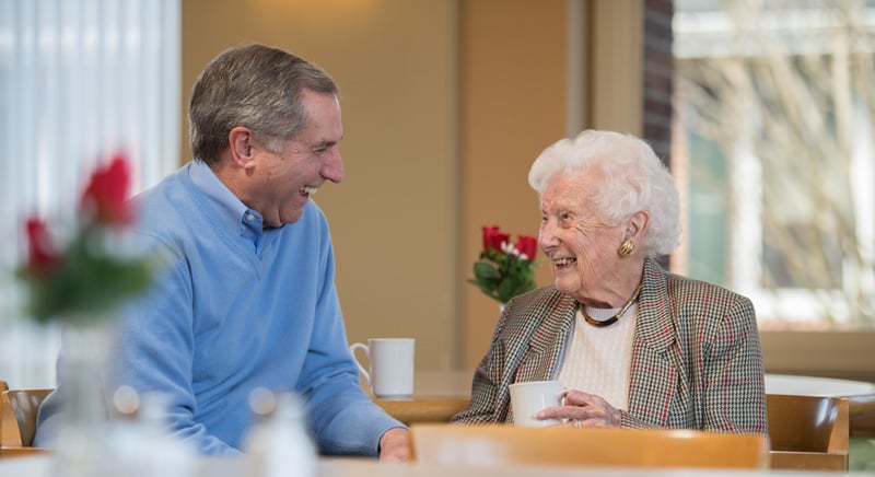 two seniors talking over coffee